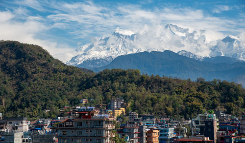 Panoramic shot of townscape and mountains against sky