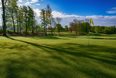 Scenic view of golf course against sky