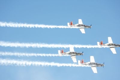 Low angle view of airshow against clear sky