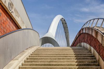 View from a pedestrian staircase leading up to de oversteek bridge, towards the bridges steel arch