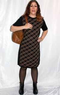 Portrait of young woman standing against wall