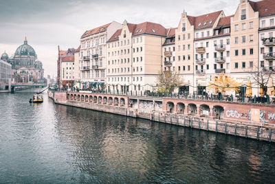 View of boats in river with buildings in background