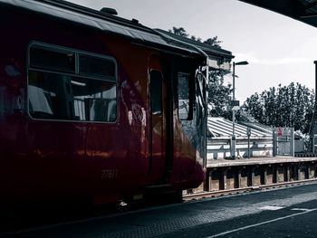 Train at railroad station in city against sky