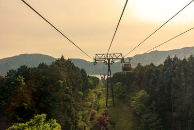 Low angle view of overhead cable car against sky