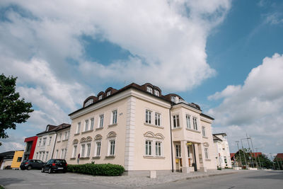 Cars on road by buildings against sky