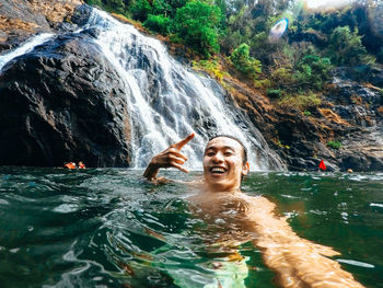 Portrait of people swimming in water at rock