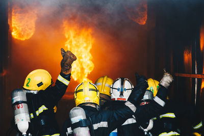 Rear view of firefighters extinguishing fire 