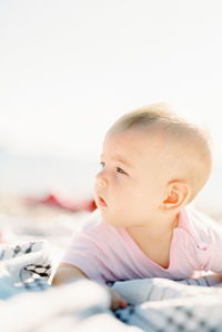 Close-up of cute baby boy lying on bed at home