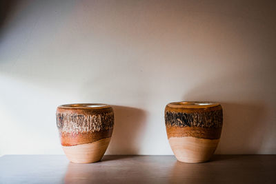 Close-up of coffee cup on table against wall