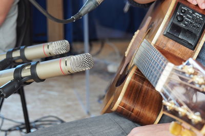 Low section of man wearing guitar