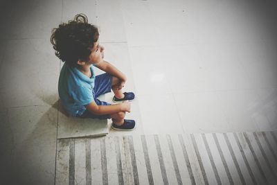 Boy sitting on wall