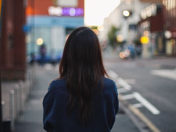 Rear view of woman in city at night