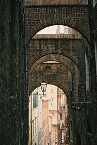 Low angle view of arch amidst old buildings