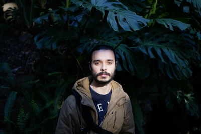 Portrait of man standing against tree