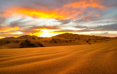 Scenic view of desert against sky during sunset