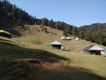 Houses on field against clear sky