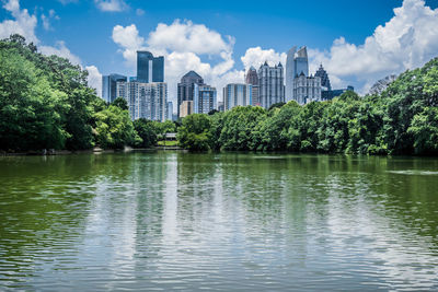 Scenic view of lake by buildings against sky