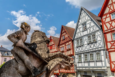 Low angle view of statue against buildings in city