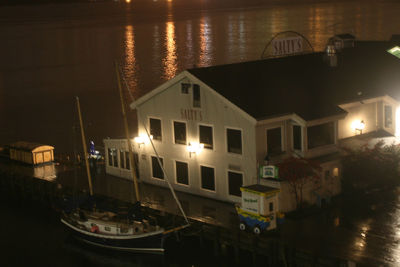 Illuminated buildings by canal at night