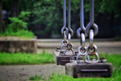 Close-up of empty swings at playground