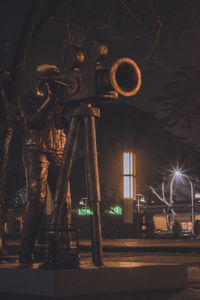 Illuminated street light against building at night