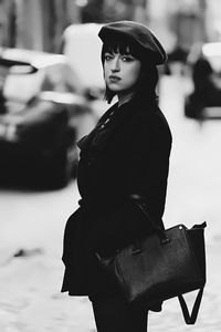 Portrait of young woman standing on street