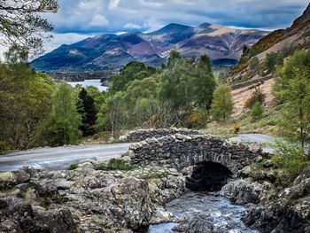 Scenic view of river amidst mountains against sky