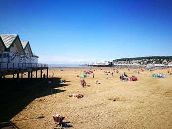 People on beach against clear sky