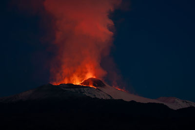 Scenic view of volcanic mountain against sky at night