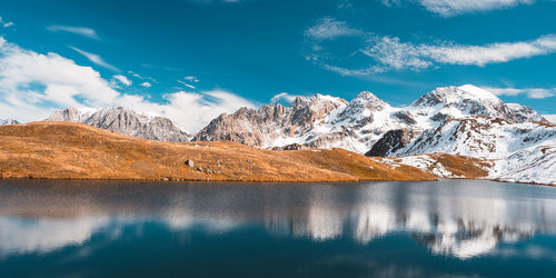 Scenic view of lake and snowcapped mountains against sky