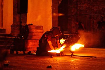 Silhouette man with fire burning at night