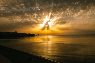 Dramatic sunset over the sea in cloudy sky, beautiful nature scene, horizon over water.