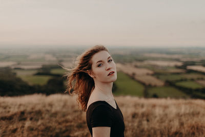 Portrait of woman standing on field against sky