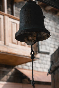 Low angle view of electric lamp hanging in old building
