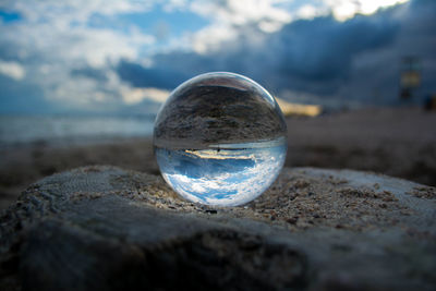 Close-up of crystal ball on sand