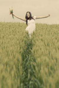 Woman in field against sky
