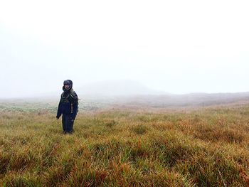 Full length of man walking on field against clear sky