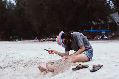 Woman sitting on sand at beach