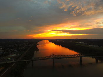 Scenic view of sunset over river and silhouette landscape