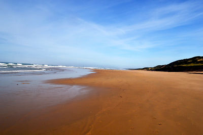Scenic view of beach against blue sky