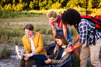 Side view of friends standing on field