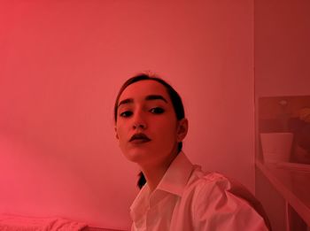 Portrait of young woman in red illuminated room