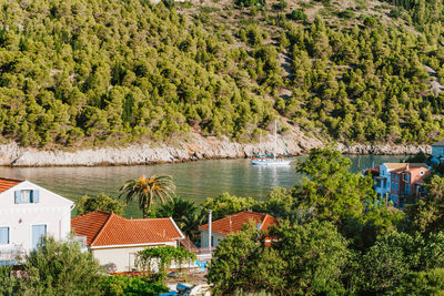 High angle view of river amidst trees and buildings