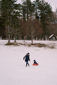 Man sitting on snow covered field