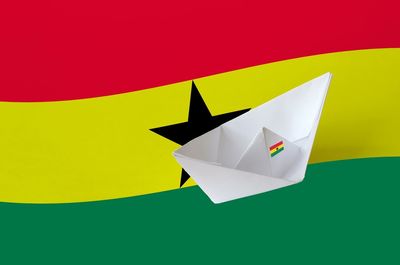 Close-up of paper flag against colored background