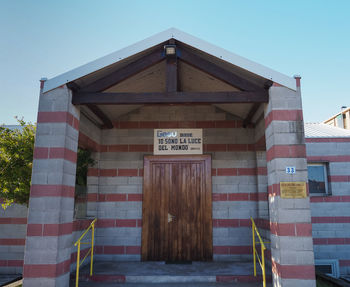 Low angle view of text on building against clear sky