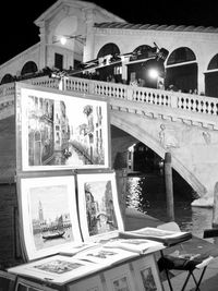 Arch bridge over canal in city at night