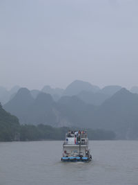 Boat in sea against mountains in li river, guilin, china,