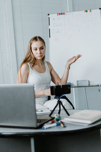 Young woman using smart phone on table