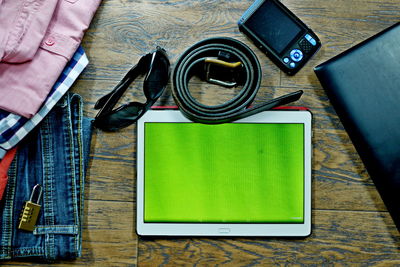 Directly above shot of technologies and personal accessories on wooden table